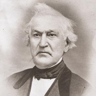 A photograph of David Whitmer. He appears to be frowning a bit. His white hair is somewhat unkempt. He wears a midtone coat, dark vest, dark tie or cravat, and white shirt.